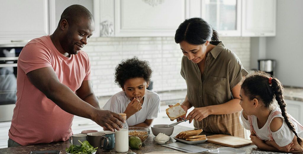 A happy family preparing lunch in their kitchen.